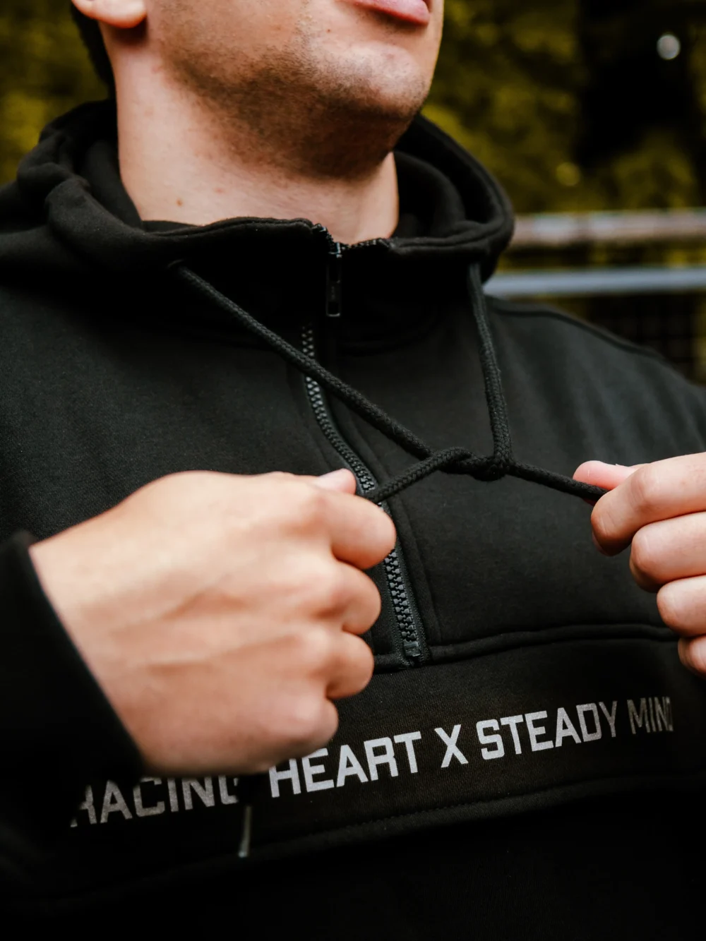 Close-up of the thick, adjustable drawstrings on the hood of the black RHSM MVMT Hoodie.