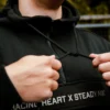 Close-up of the thick, adjustable drawstrings on the hood of the black RHSM MVMT Hoodie.