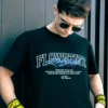 Outdoor close-up shot of a model wearing the black RHSM Flowstate graphic tee.