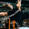 Calisthenics champion Daniels Laizans performing an elite one-arm front lever while wearing the RHSM Godmode Tank Top.