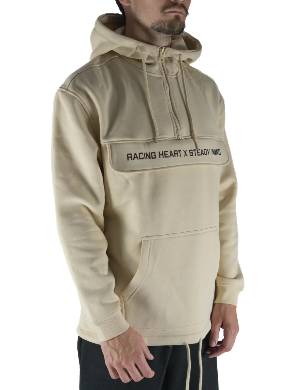 Front view of a model wearing the beige RHSM MVMT Hoodie, highlighting its oversized streetwear fit.