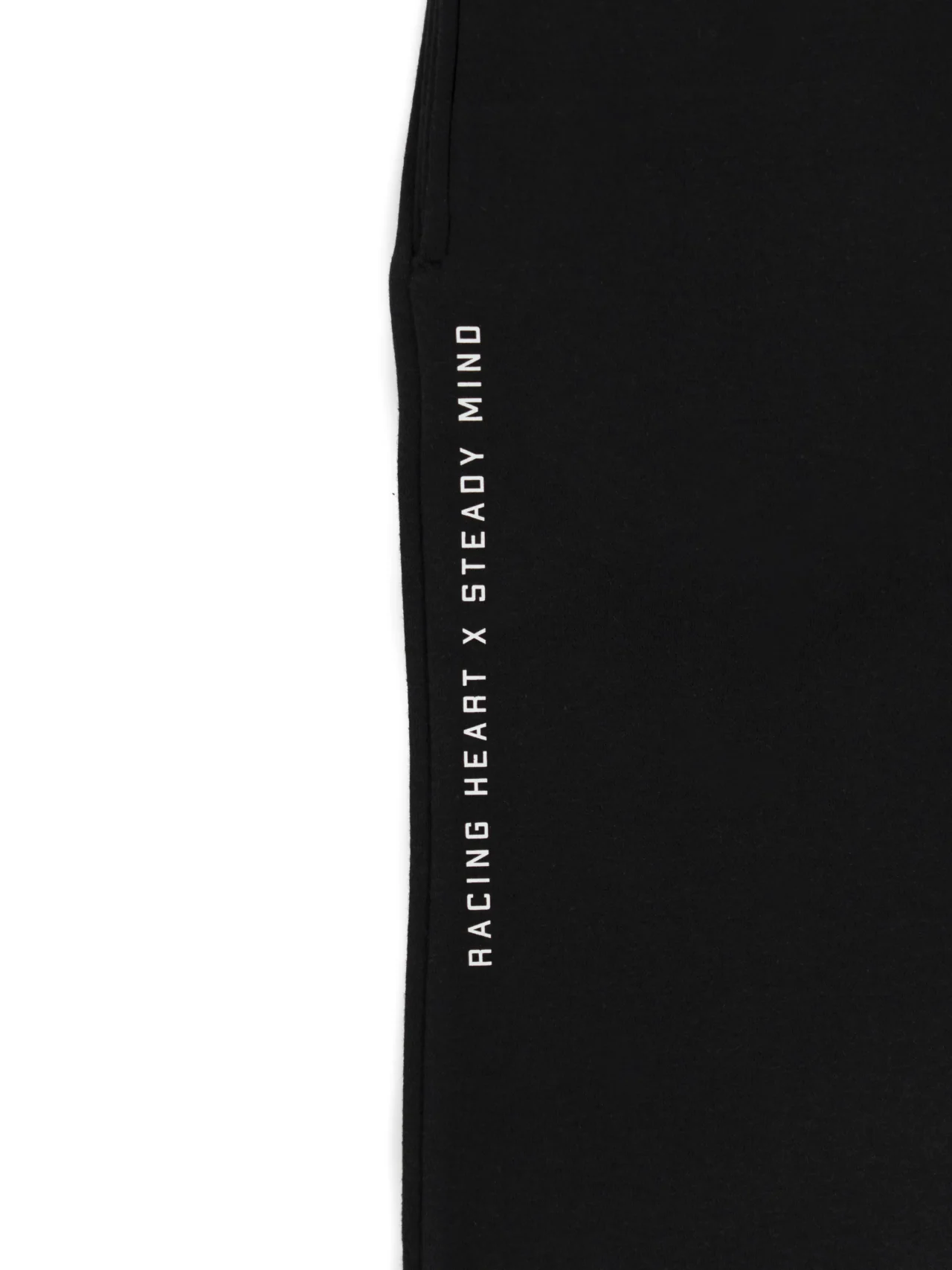 A close-up of the deep pocket and "Racing Heart X Steady Mind" graphic on the black RHSM Classic Fit Sweatpants.