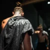 A stylistic back view of an athlete with the RHSM Acid Wash Tee on his shoulder after a calisthenics workout.