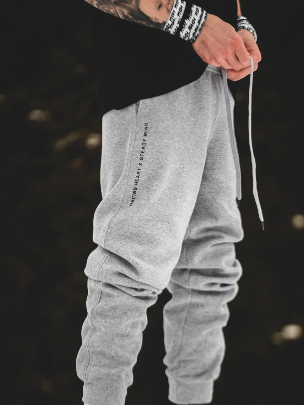 A full side view of a model wearing the gray RHSM Classic Fit Sweatpants outdoors, showcasing the modern silhouette.