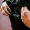 Close-up of the front pouch on the RHSM MVMT Hoodie being used to carry everyday essentials like wrist wraps.