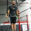 An athlete using gymnastic rings for a calisthenics workout while wearing the RHSM Acid Wash Tee.