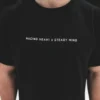 An outdoor close-up of the minimalist design on the black RHSM Classic Fit Tee, worn by a model.