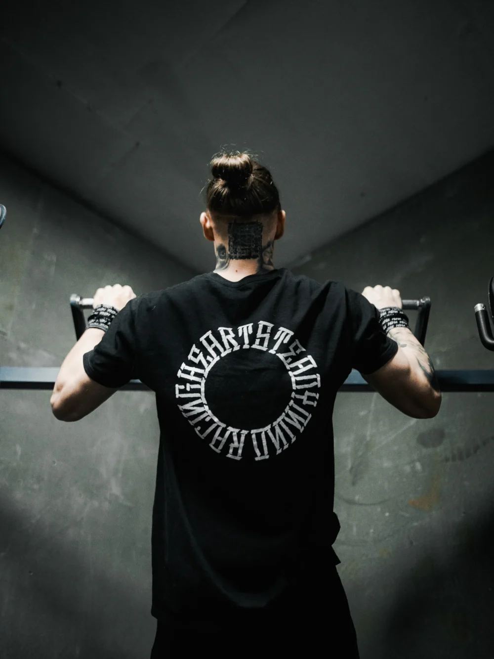 Calisthenics champion Daniels Laizans performing a pull-up while wearing the black RHSM Long Fit Tee V2.