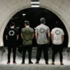 Back view of four athletes wearing all colorways of the RHSM Long Fit Tee V2, displaying the "Racing Heart Steady Mind" back graphic.