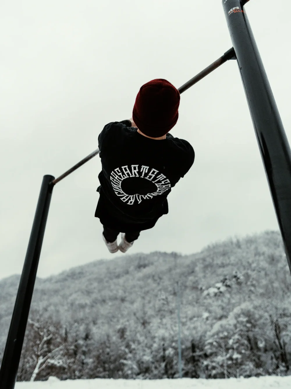 An athlete performing an advanced calisthenics front lever while wearing the RHSM Long Fit Tee V2.