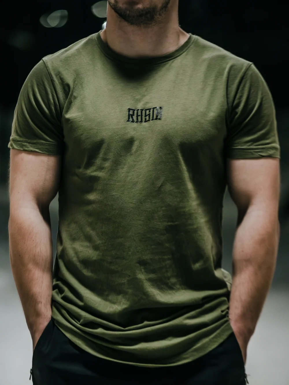 Model wearing the khaki RHSM Long Fit Tee V2 outside, showcasing its modern streetwear style.