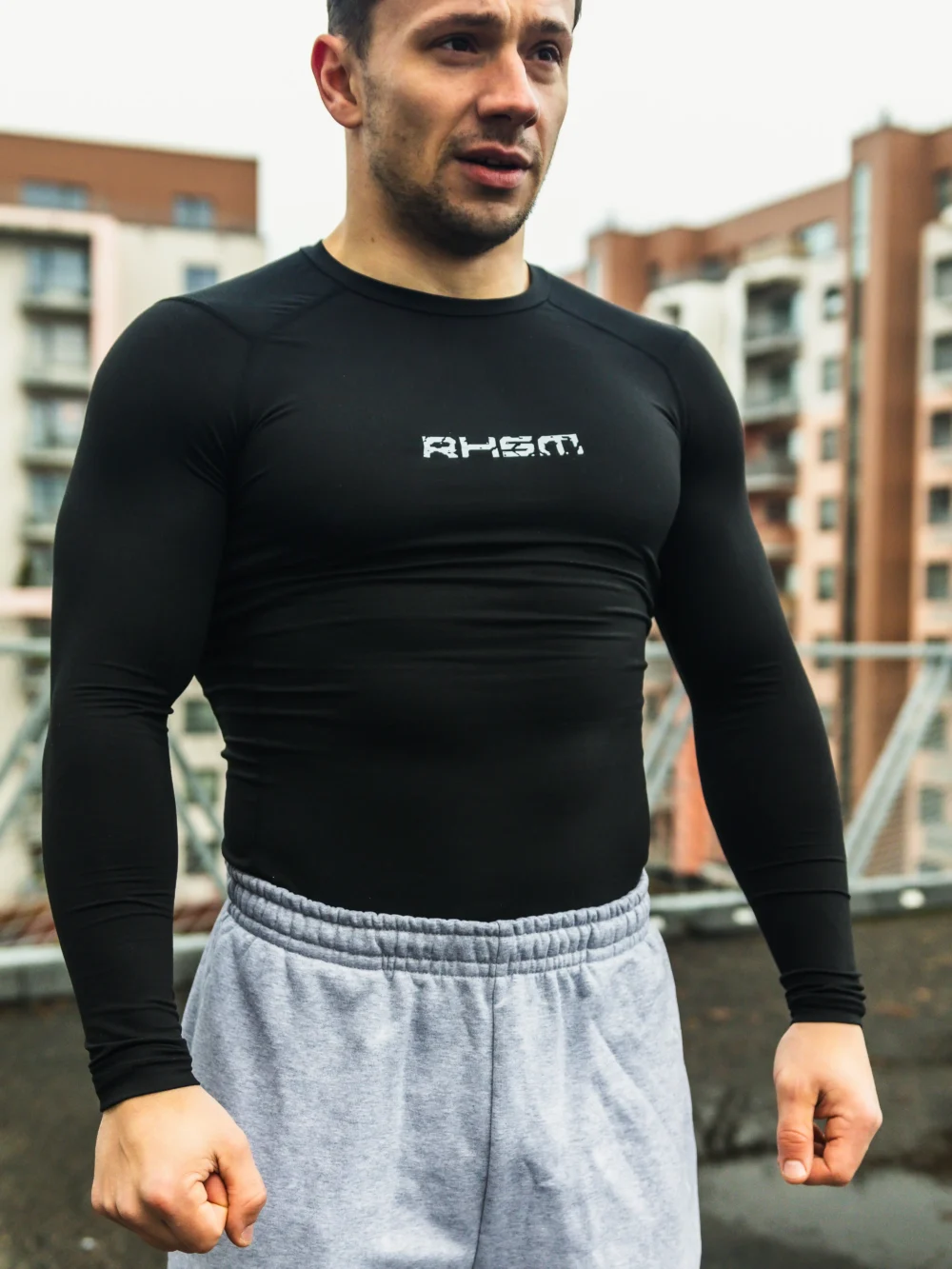 Front view of an athlete wearing the black RHSM Compression Shirt in an outdoor training setting.