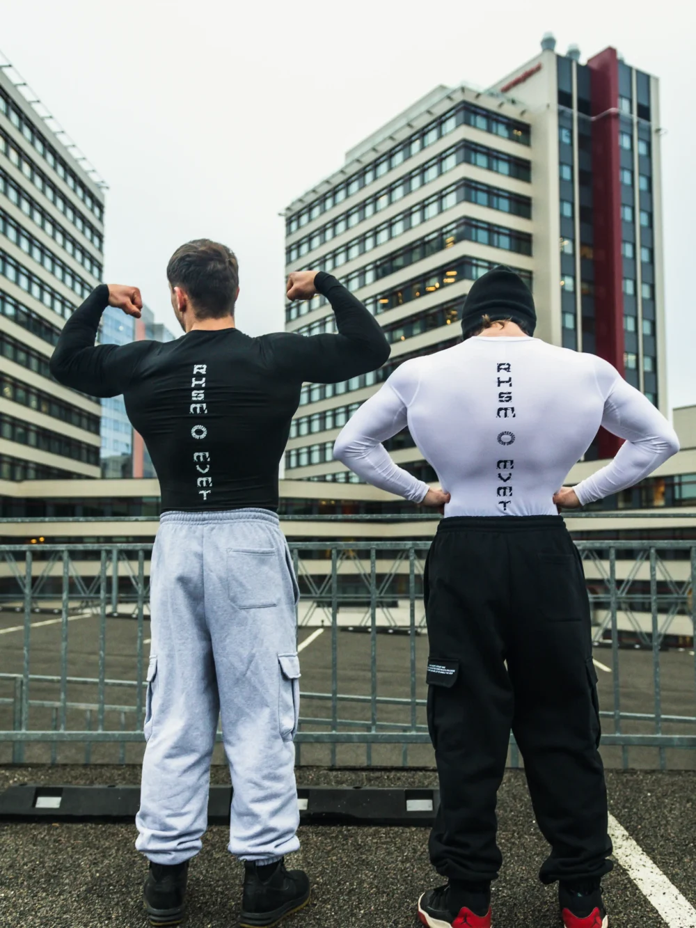 Two models posing in the RHSM Compression Shirts against a cityscape background.