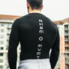 Back view of an athlete wearing the black RHSM Compression Shirt during an outdoor workout.
