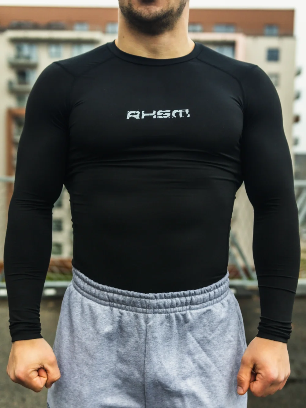 A close-up of the front of the black RHSM Compression Shirt, highlighting the material and compression fit.
