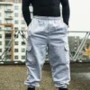Full front view of a model wearing the gray RHSM Cargo Sweatpants in an outdoor setting.