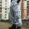 A side view of a model showing the secure latch detail on the cargo pocket of the gray RHSM Sweatpants.