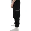 Side view of a model wearing the black RHSM Cargo Sweatpants, showcasing the functional side cargo pocket.
