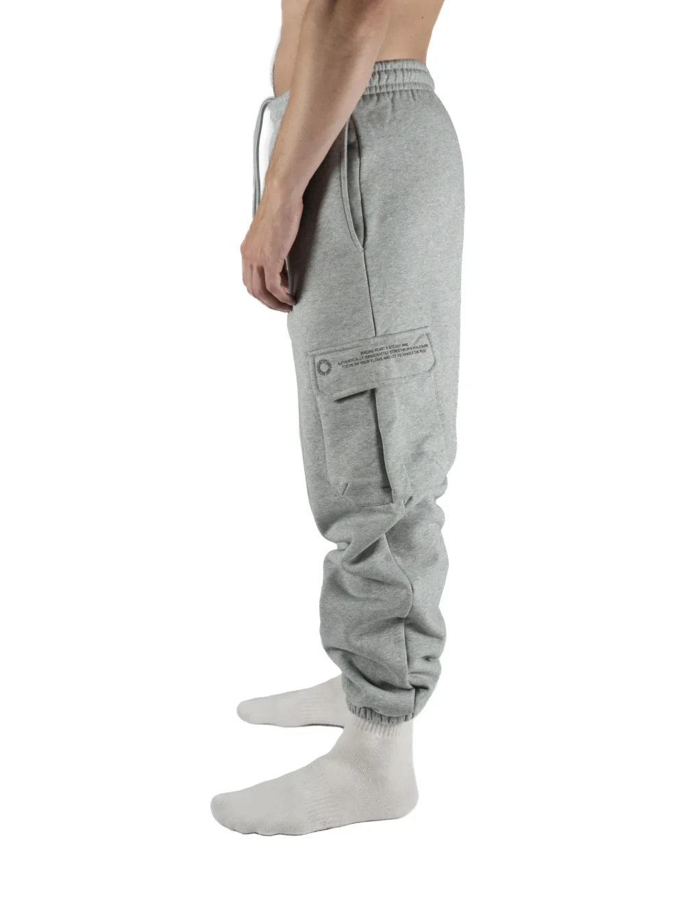 Side view of a model wearing the gray RHSM Cargo Sweatpants, showcasing the functional side cargo pocket.