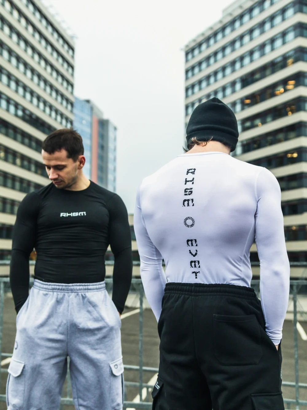 Two athletes wearing the black and white RHSM Calisthenics Compression Shirts in an urban setting.