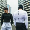 Two athletes wearing the black and white RHSM Calisthenics Compression Shirts in an urban setting.