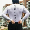 Back view of an athlete wearing the white RHSM Compression Shirt during an outdoor workout.