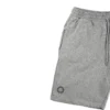 Closeup of the screen-printed RHSM First Edition emblem on the pocket of the gray cotton shorts.