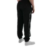 Model wearing the black "GODMODE" trackpants (back view), demonstrating the sleek design from the calisthenics clothing brand RHSM.
