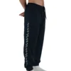 Model wearing the navy GODMODE trackpants (front view), demonstrating the comfortable athletic fit of this premium workout gear.