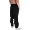 Model wearing the black "[RHXSM]" sweatpants, highlighting the modern relaxed fit and soft material of this essential workout gear.