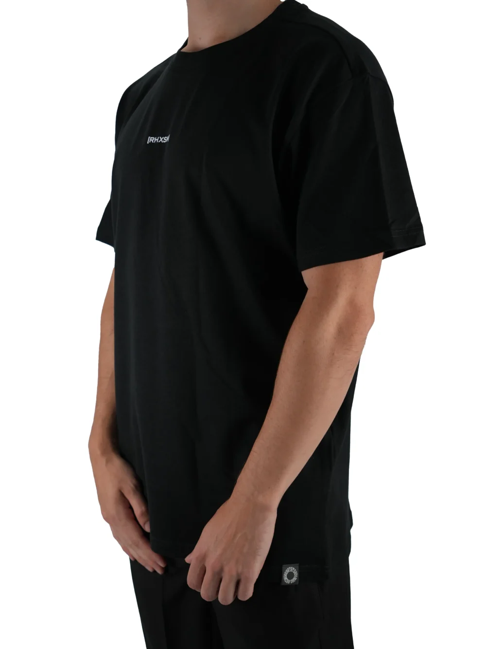 Model wearing the black oversized "[RHXSM]" tee (front view), demonstrating the loose fit and dropped shoulders of this workout gear.