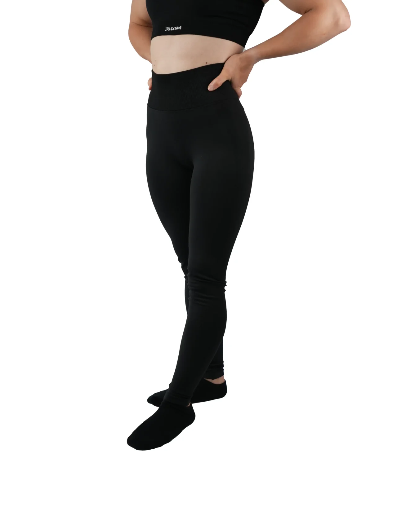 Model wearing the black "[RHXSM]" seamless leggings (front view), demonstrating the supportive, high-waisted fit of this women's workout gear.