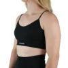 Model wearing the black "[RHXSM]" seamless sports bra (front view), demonstrating the supportive, medium-impact fit of this women's workout gear.