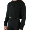 Model wearing the black "[RHXSM]" terry cropped crew (front view), demonstrating the oversized, belly-free fit of this women's workout gear.