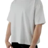 A female model wearing the white oversized boxy tee from the front, demonstrating its modern boxy silhouette and dropped shoulder fit.