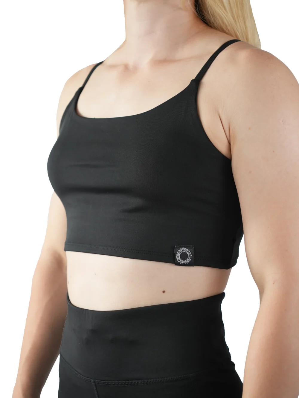 Model wearing the black RHSM Minimalist Sports Bra, demonstrating the secure, slim fit of the fitness apparel.
