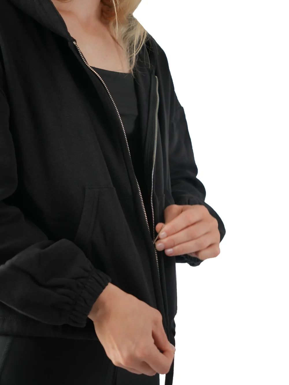 Close-up of the model showcasing the full-zip track feature on the black minimalist hoodie from the RHSM calisthenics clothing brand.