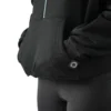 Model using the front kangaroo pocket on the black RHSM minimalist hoodie.