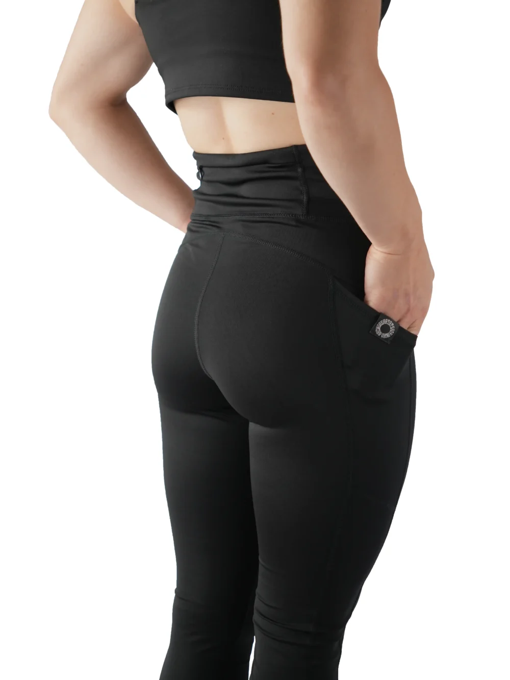Model using the deep side pocket on the black leggings, essential workout gear from the RHSM calisthenics clothing brand.