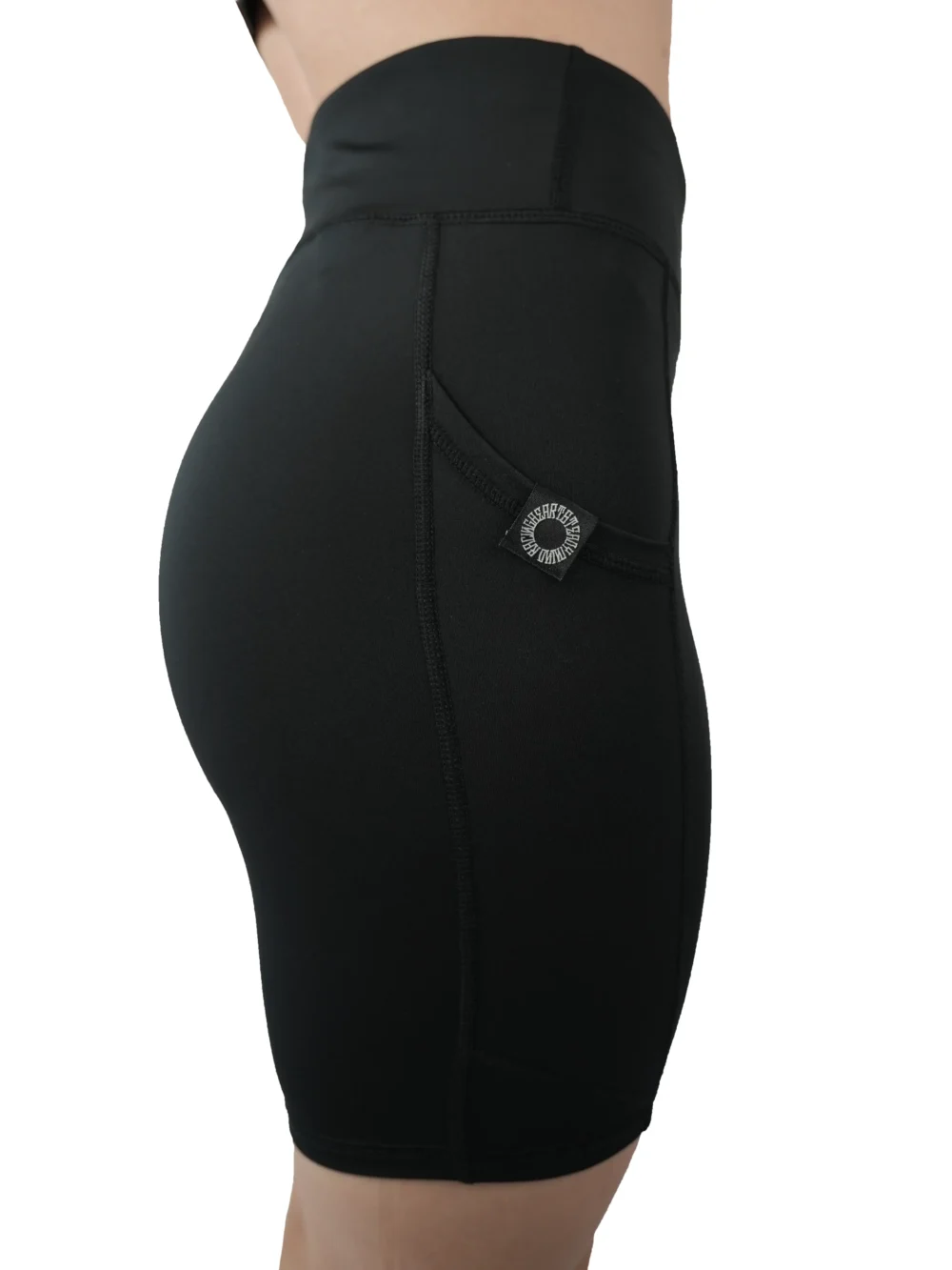 Model in a side profile wearing the black RHSM shorts, demonstrating the ergonomic fit and side pocket.