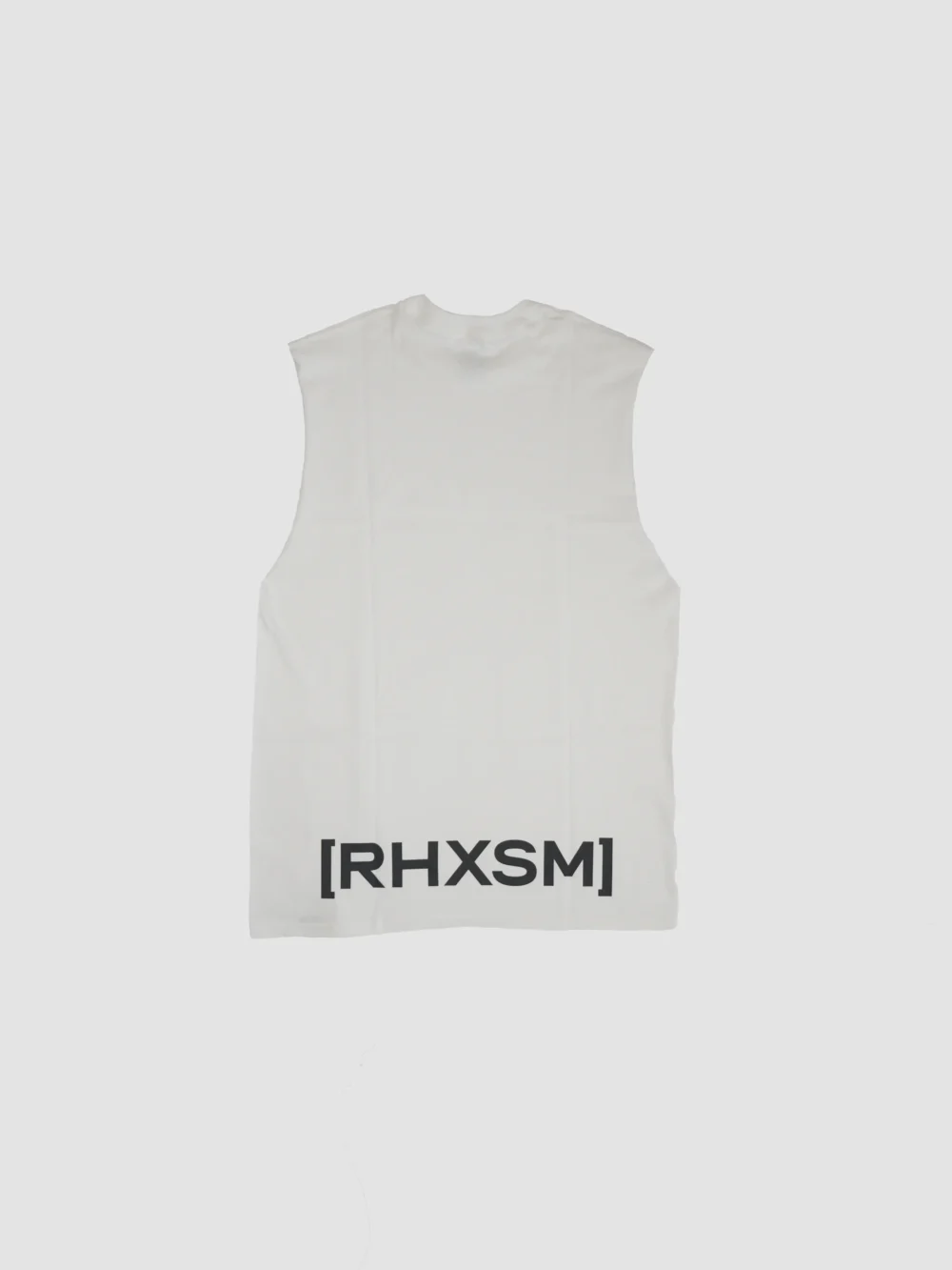 The white "[RHXSM]" oversized tank, laid flat (back view), detailing the bold statement back graphic on this piece of calisthenics apparel.