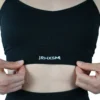 A close-up of the black "[RHXSM]" sports bra, detailing the premium embroidered front graphic on this piece of performance apparel.