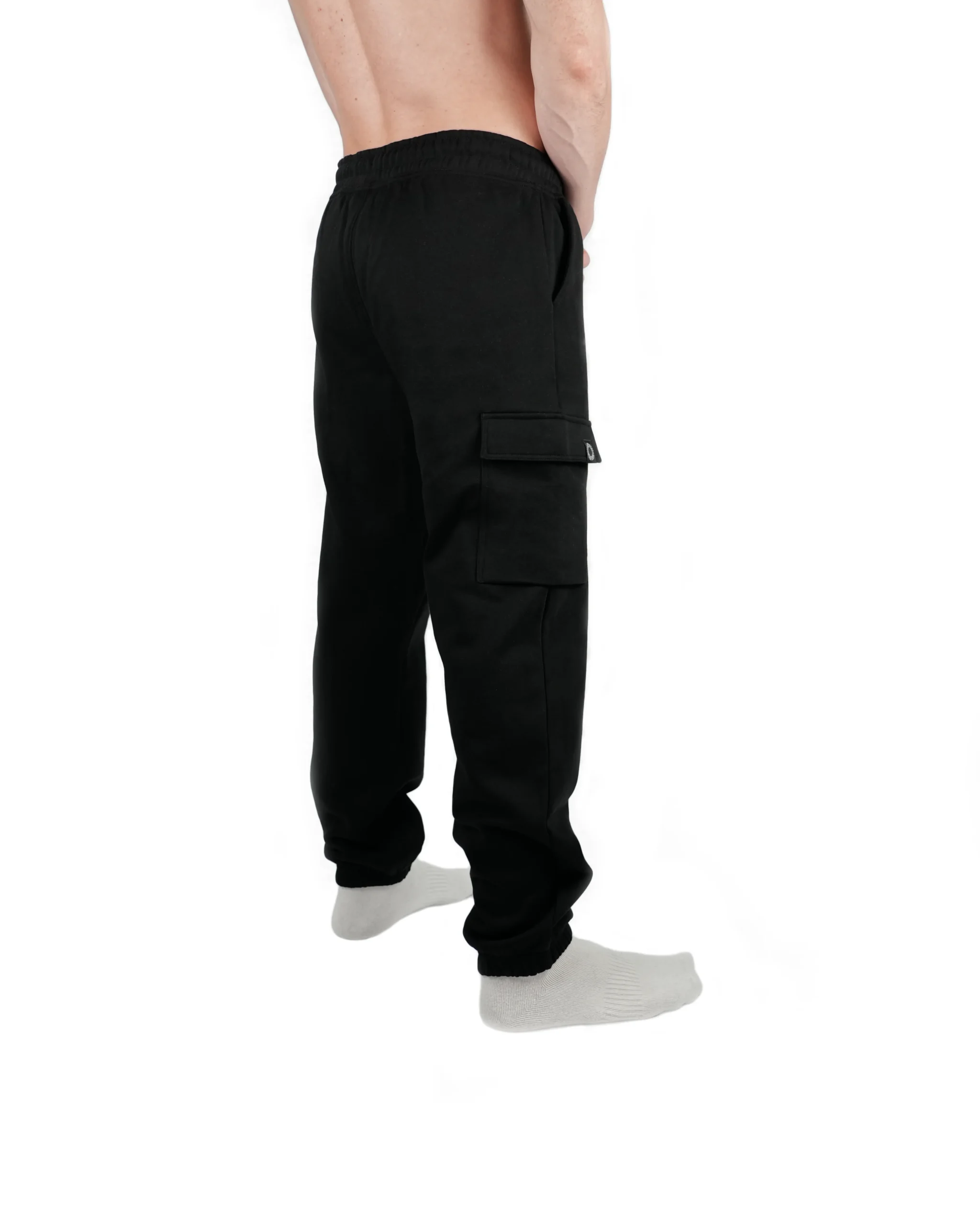 Rear view of a model wearing black RHSM lightweight cargo sweatpants, showing the tapered leg fit and lighter material drape.