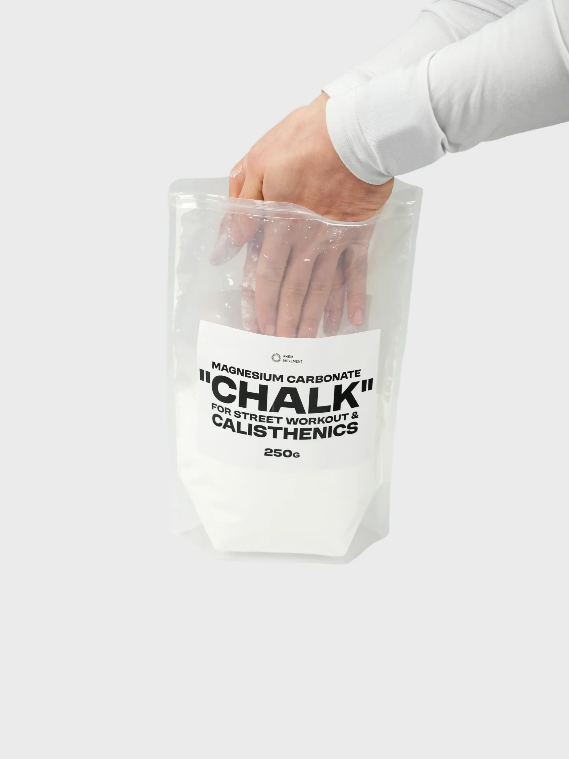 Athlete reaching into the RHSM chalk bag to apply magnesium carbonate, highlighting the high-purity powder for calisthenics apparel fans.