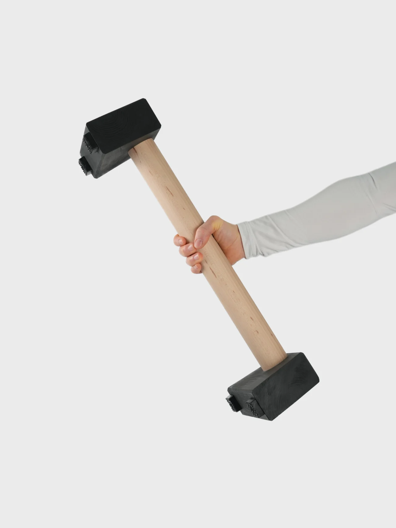Athlete holding the 5cm diameter beech handle of an RHSM Large Parallette, demonstrating heavy-duty workout gear portability.