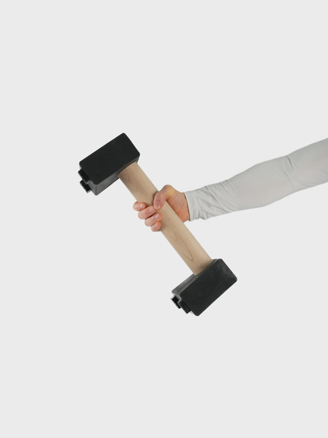 Athlete holding the 5cm diameter beech handle of an RHSM Medium Parallette, essential high-performance fitness apparel equipment.